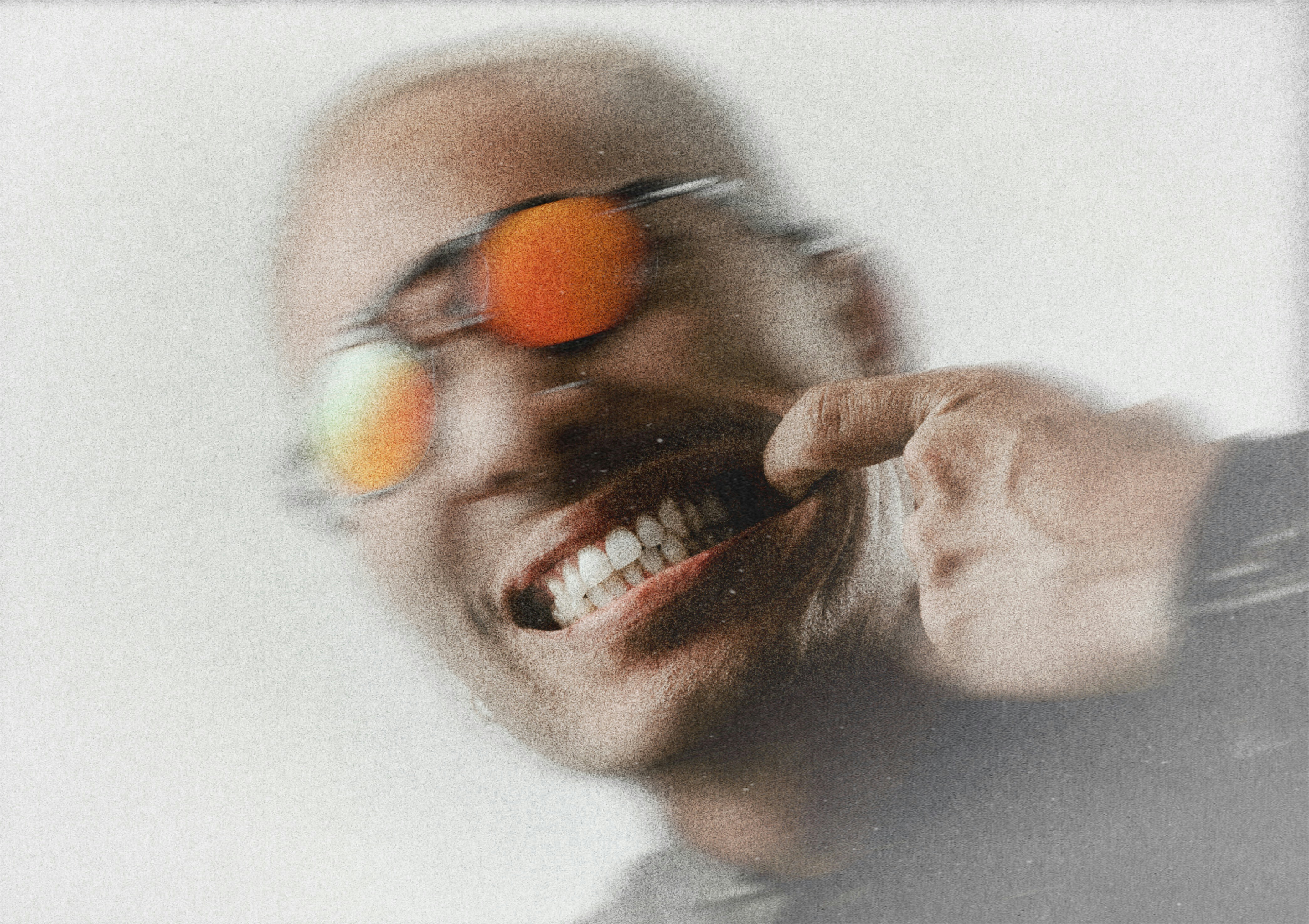 L'uomo con gli occhiali da sole punta i denti