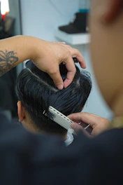 Barber styling man's hair with comb