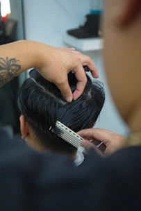 Barber styling man's hair with comb