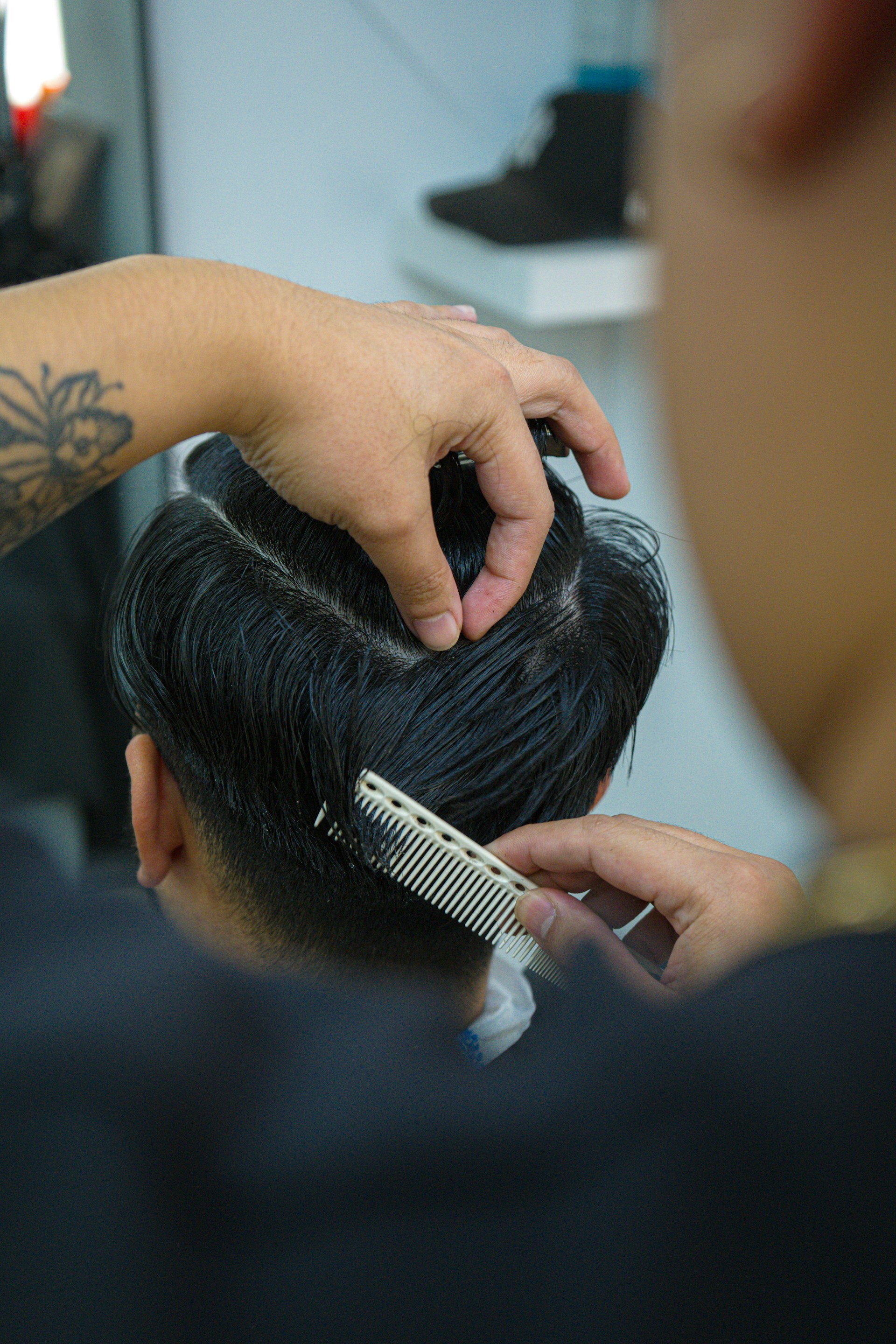 Barber styling man's hair with comb