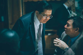 Two businessmen in suits talking intently