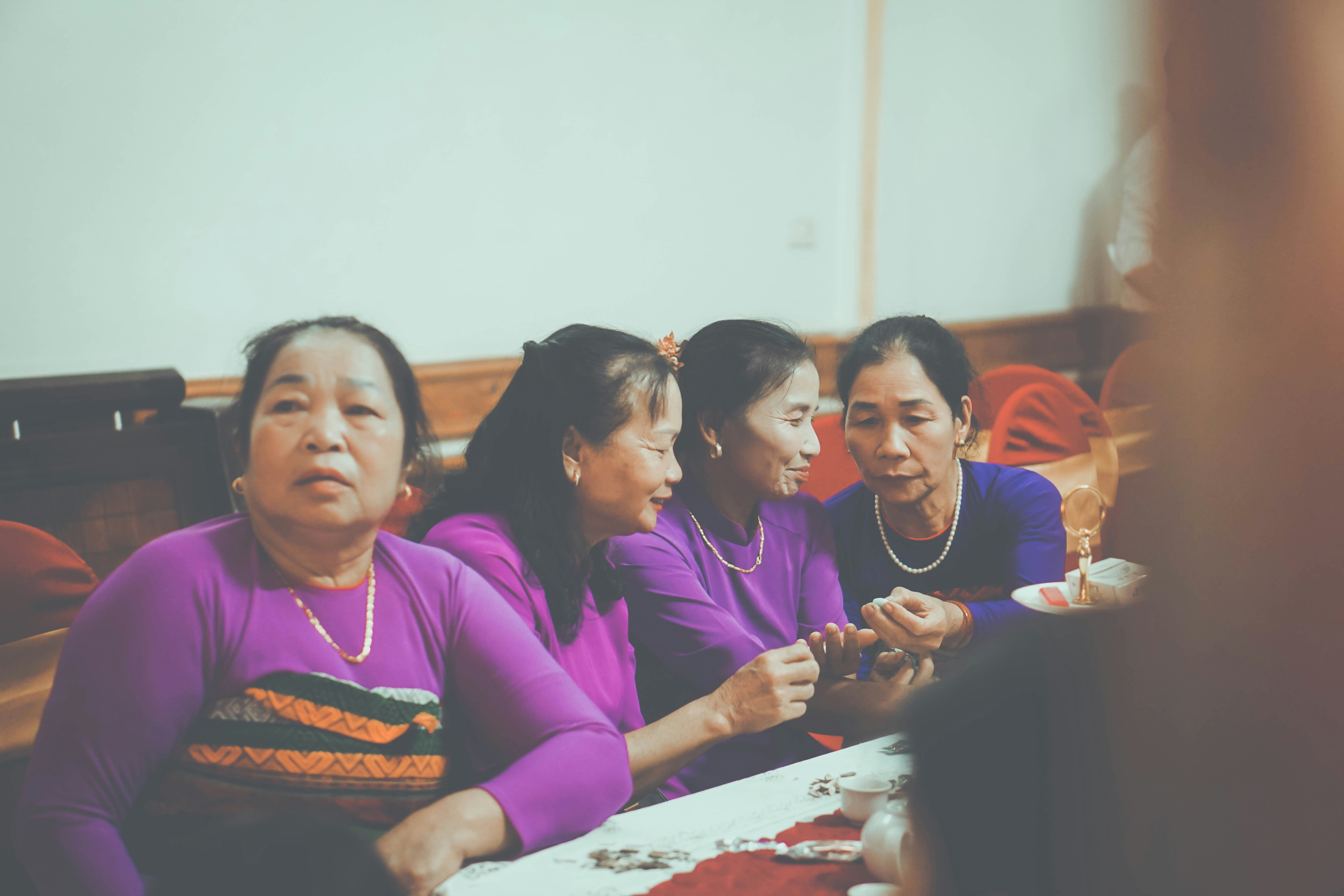 Four women in purple shirts gathered around a table