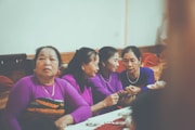 Four women in purple shirts gathered around a table