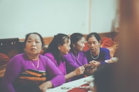 Four women in purple shirts gathered around a table