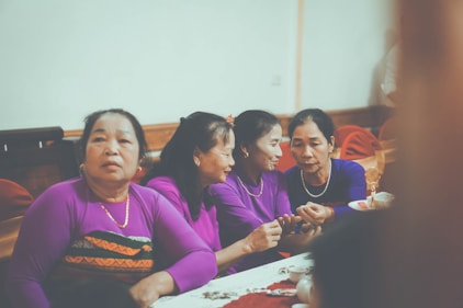 Four women in purple shirts gathered around a table