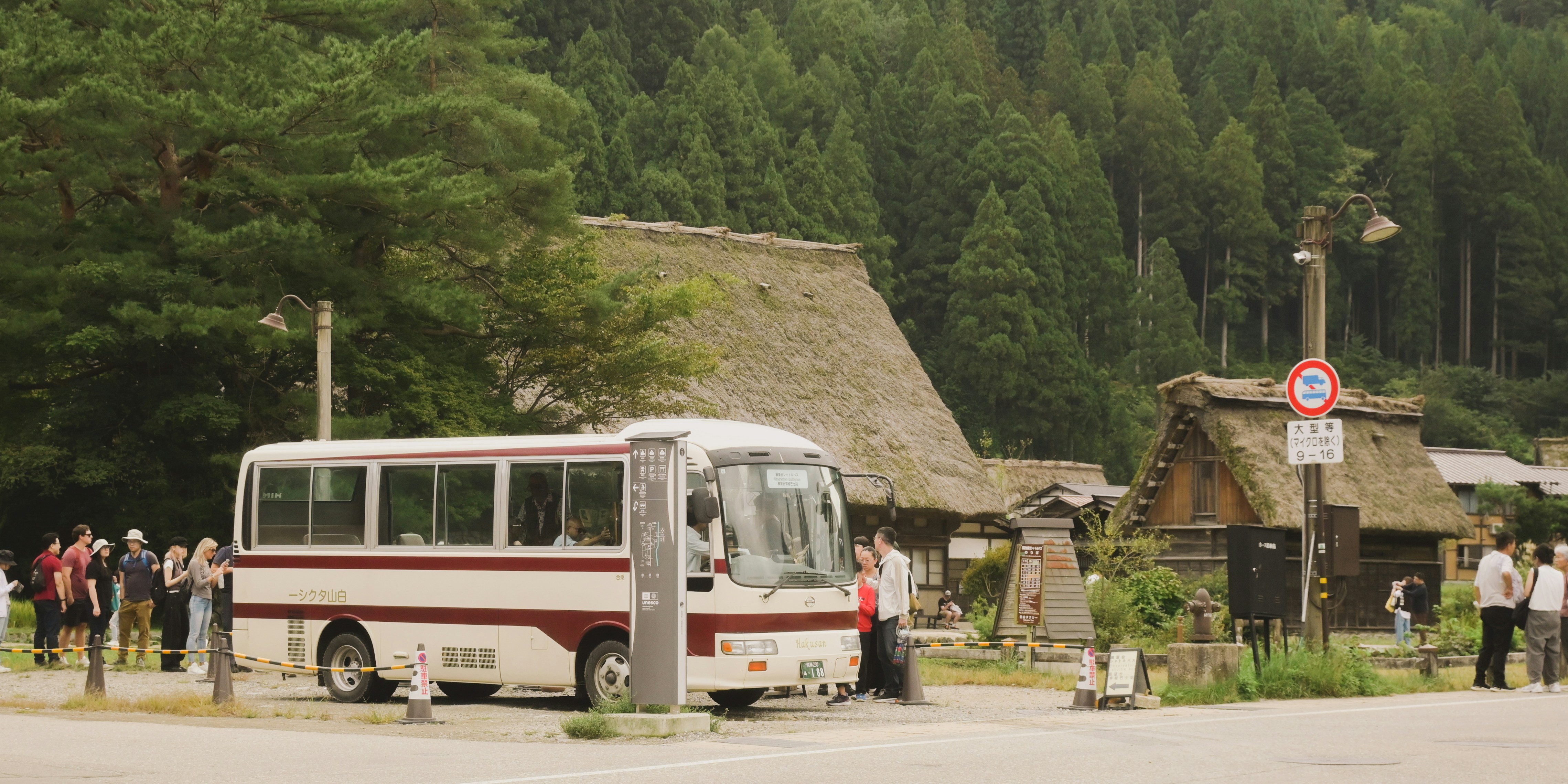 Bus parked near traditional thatched roof houses