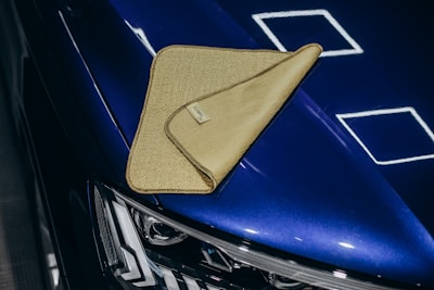 A microfiber cloth rests on a shiny blue car.