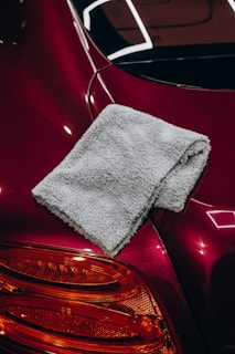 Gray microfiber cloth resting on a red car