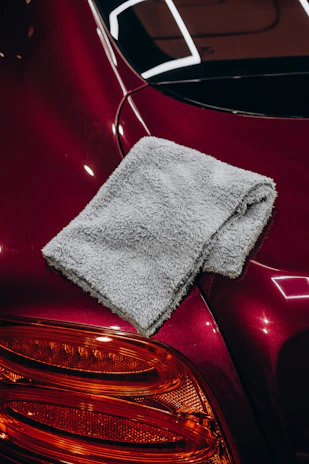 Gray microfiber cloth resting on a red car