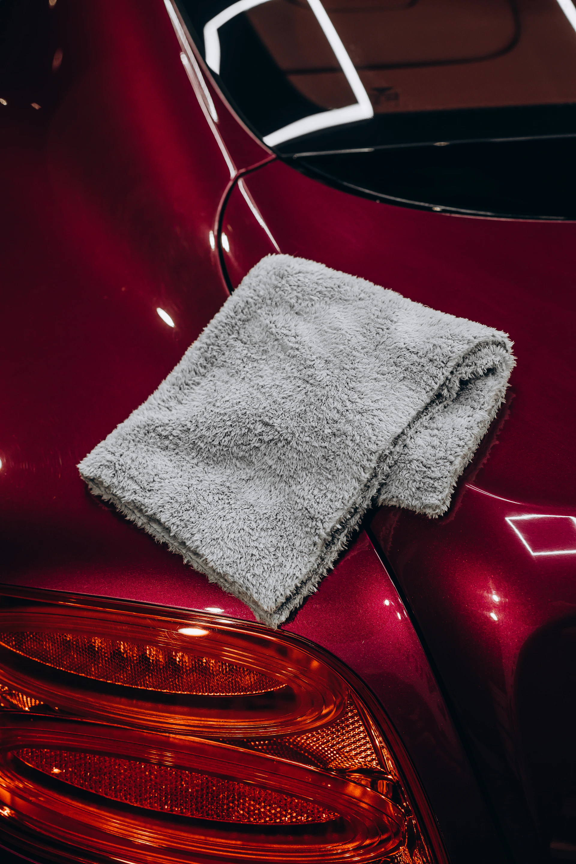 Gray microfiber cloth resting on a red car