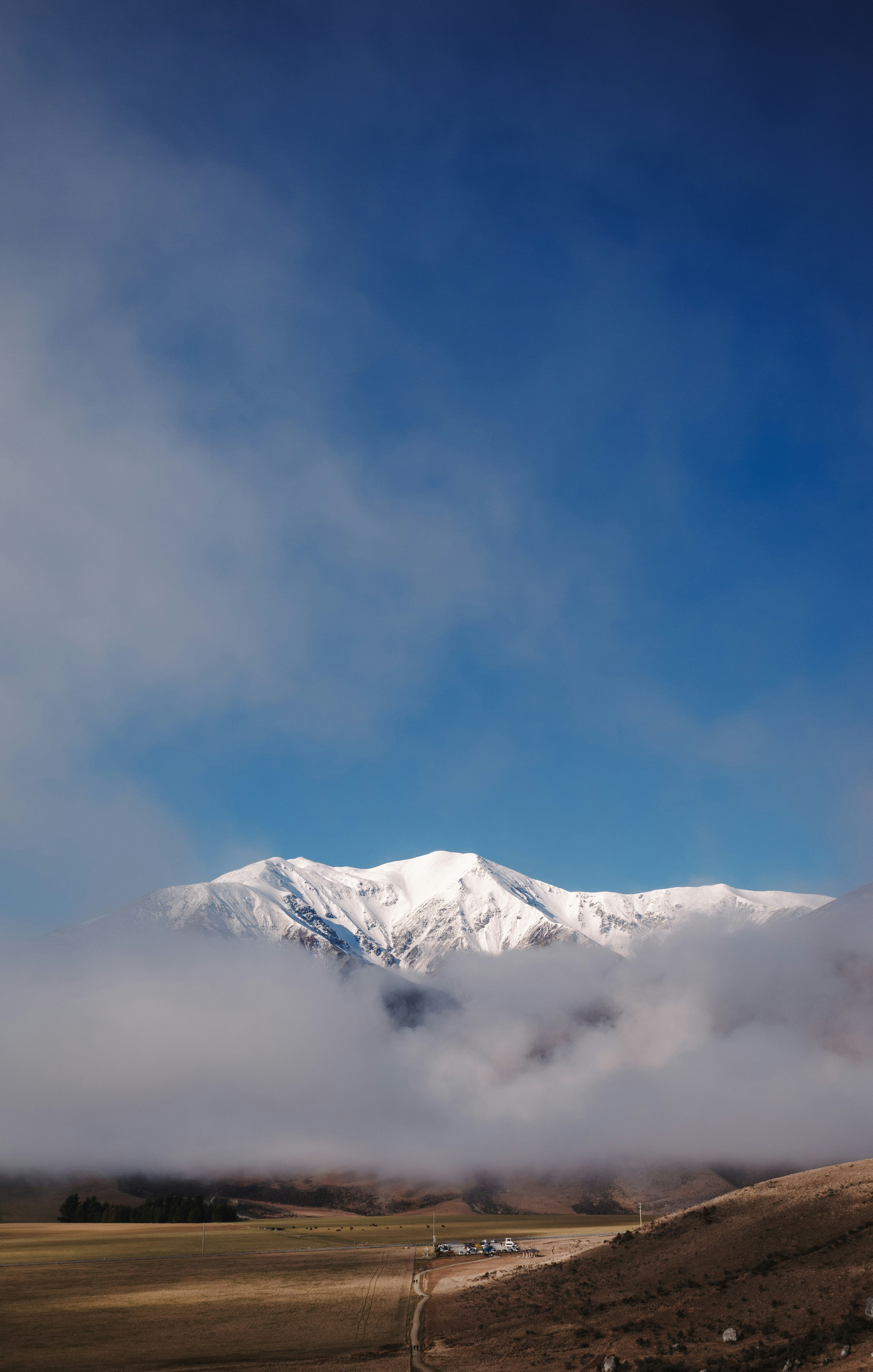 Snow-capped mountains emerge from low clouds