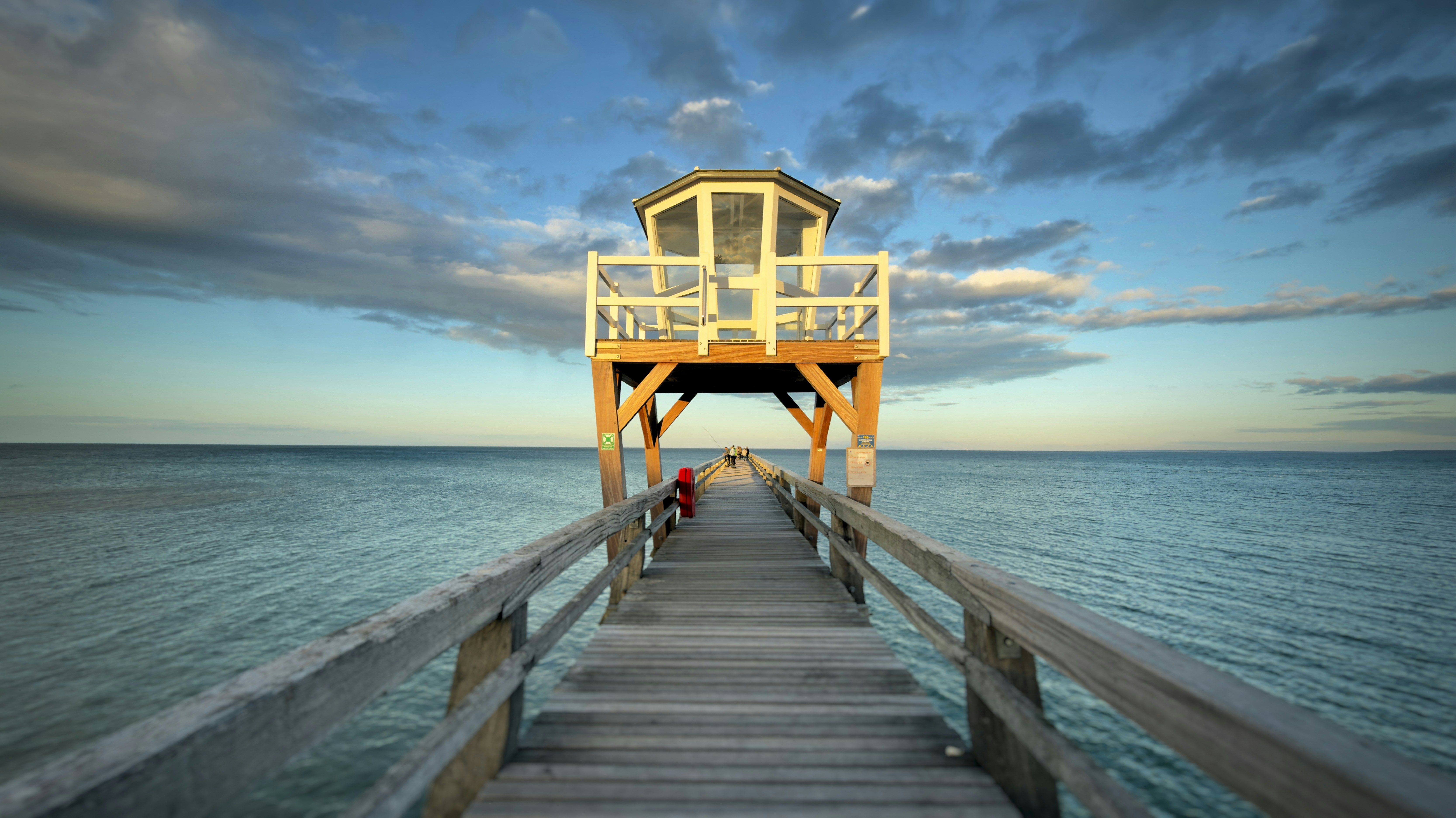 Wooden pier with lifeguard tower over calm ocean