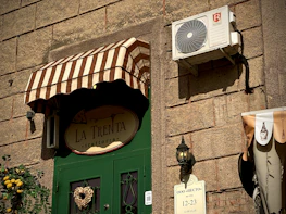 Restaurant awning over a green door with sign.