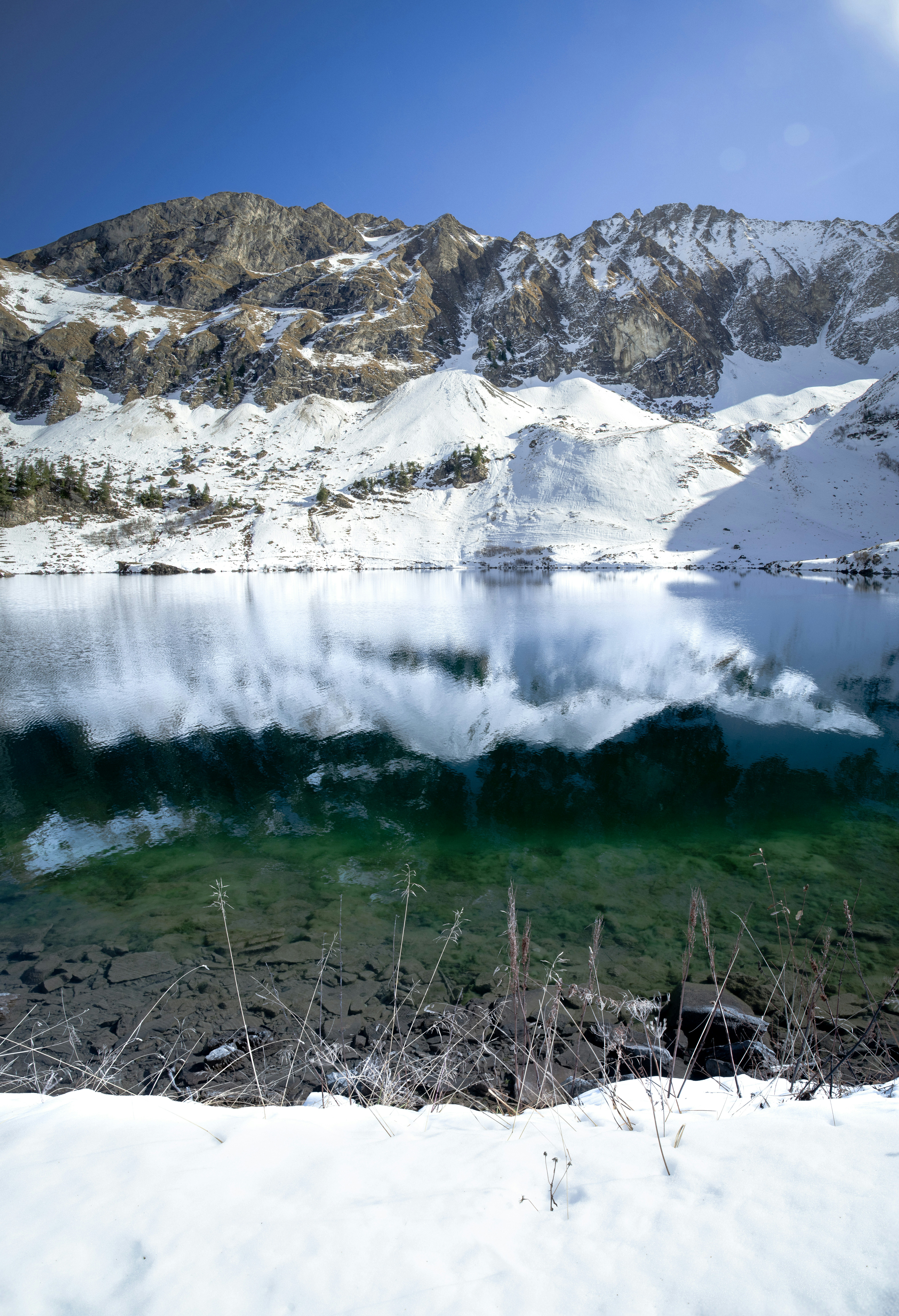 Snowy mountains reflected in a clear lake