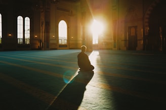 Person sitting in a large, sunlit hall