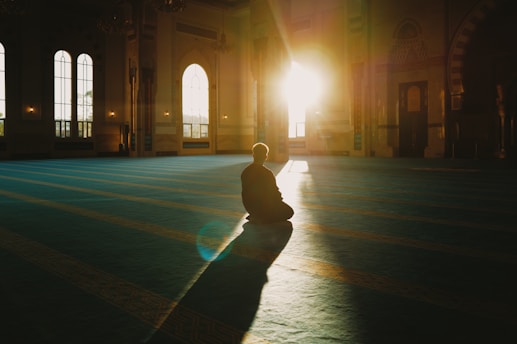 Person sitting in a large, sunlit hall