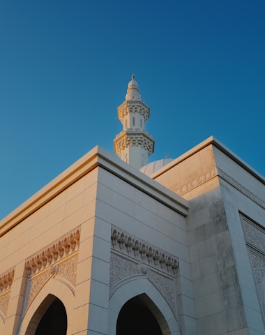 A mosque minaret against a clear blue sky.
