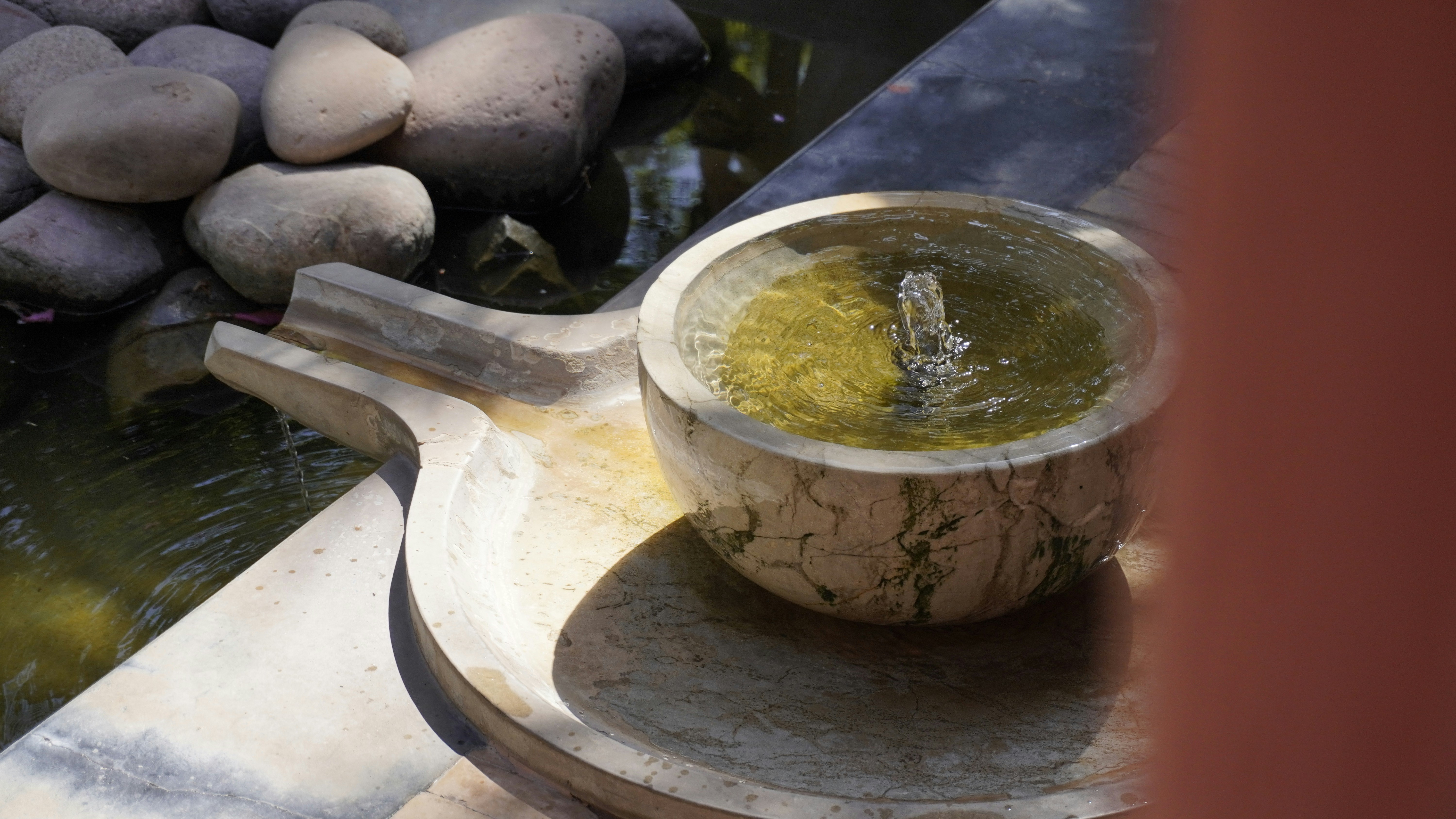 Stone fountain with water and mossy bowl.