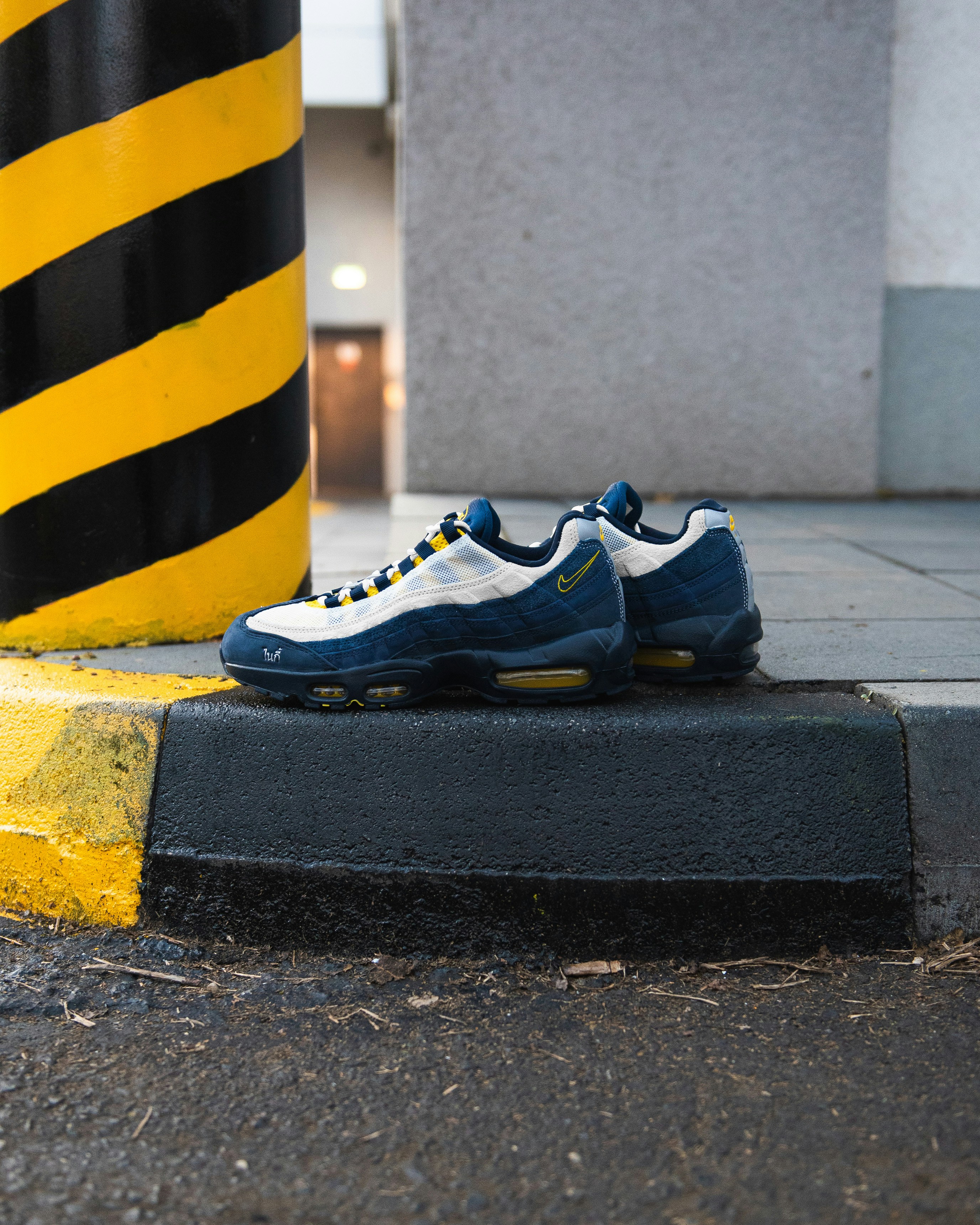 Pair of blue and white sneakers on curb