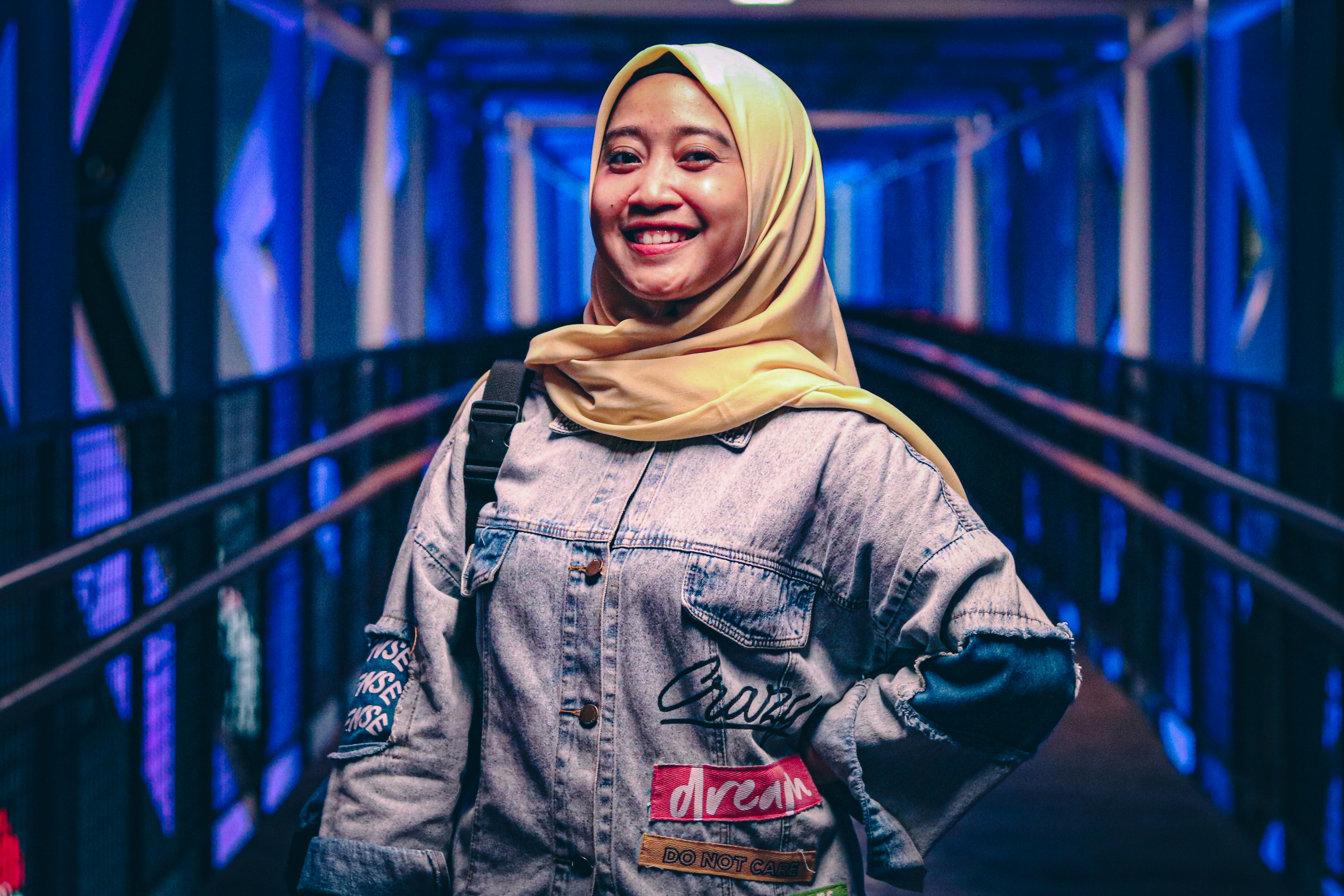 Young woman in hijab standing on illuminated walkway