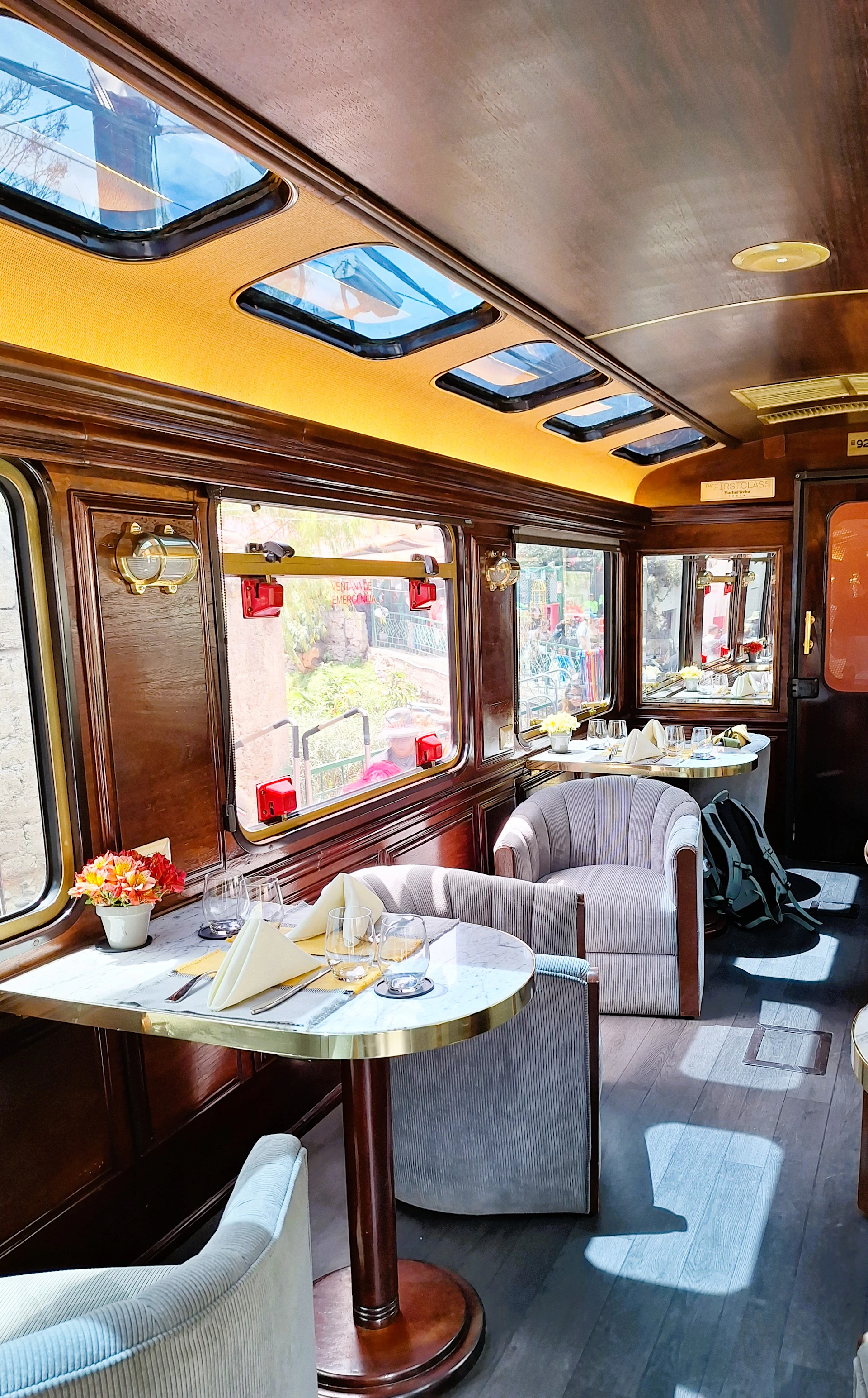 Luxurious train carriage interior with dining tables and seating.