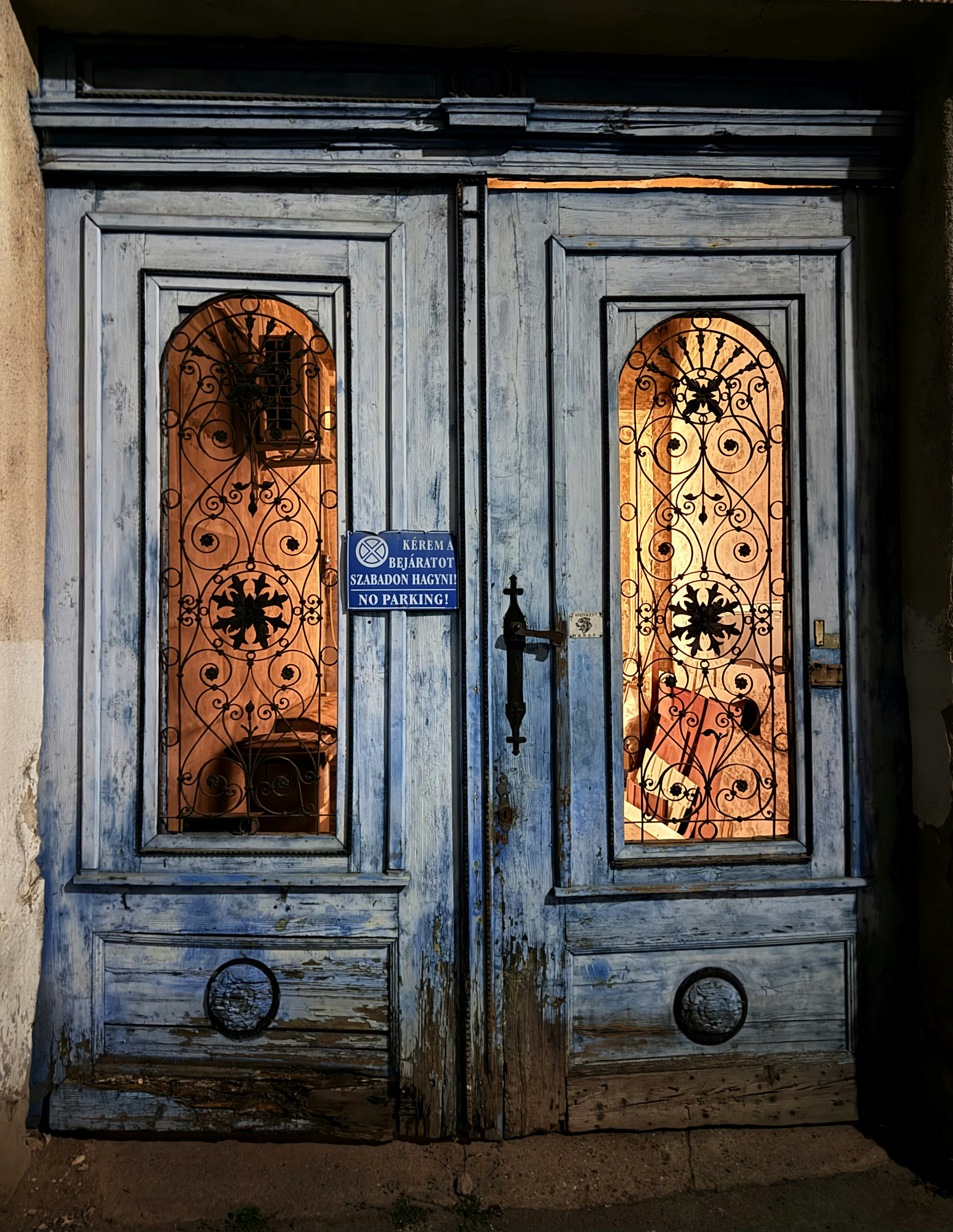 Portas duplas azuis velhas desgastadas com metalurgia ornamentada