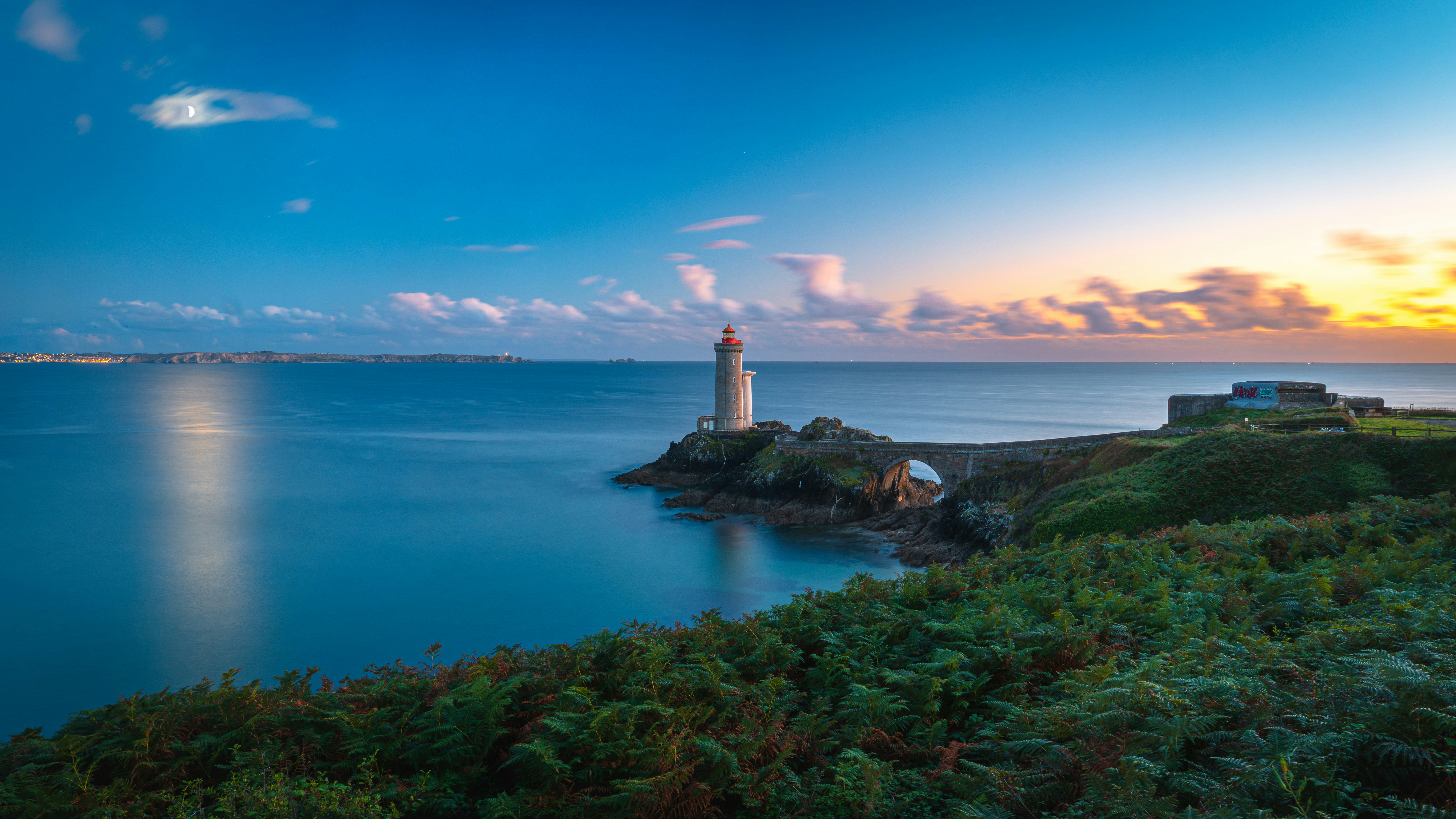 Lighthouse on a rocky coast at sunset