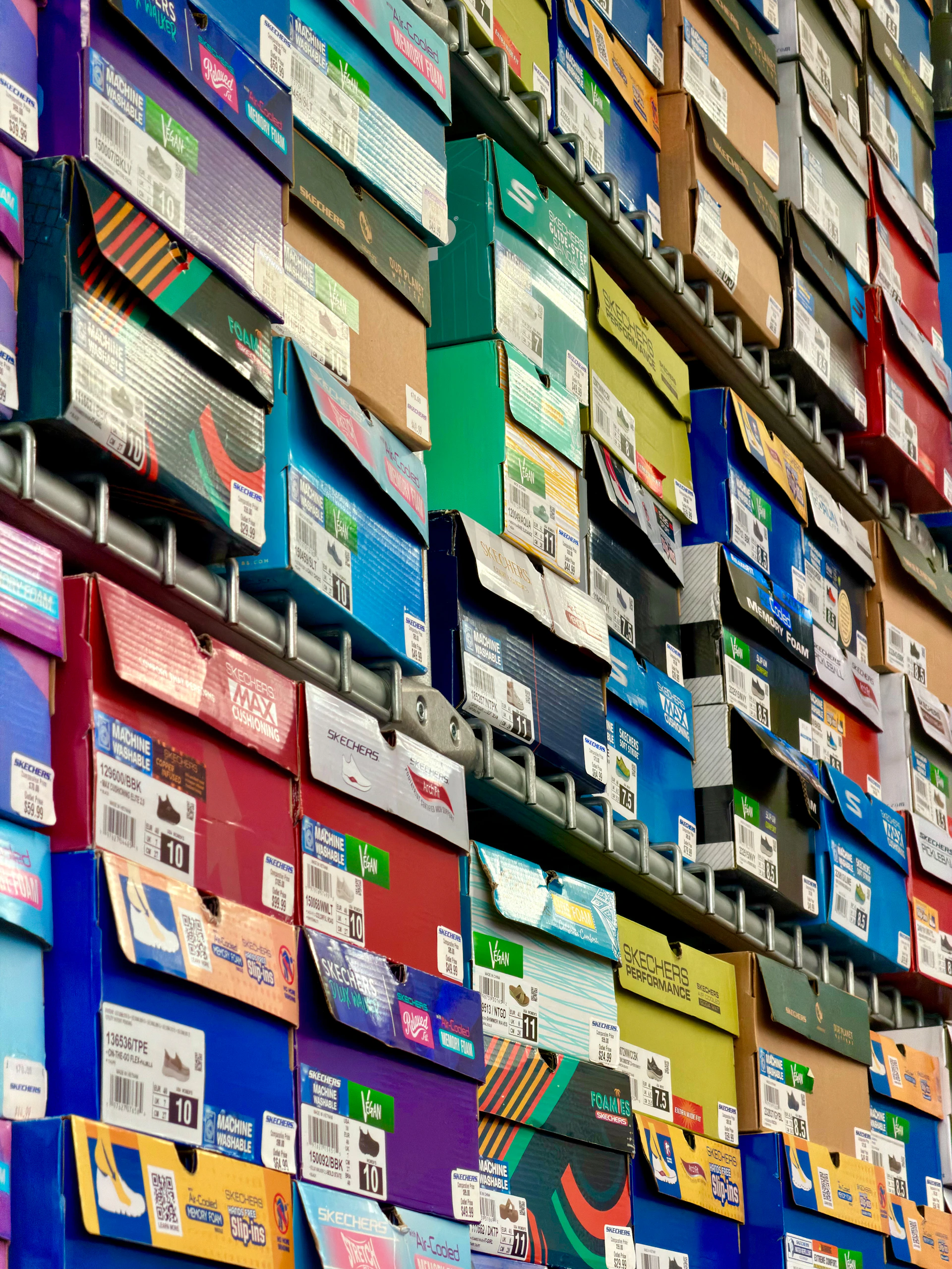 Colorful shoe boxes stacked high on shelves.