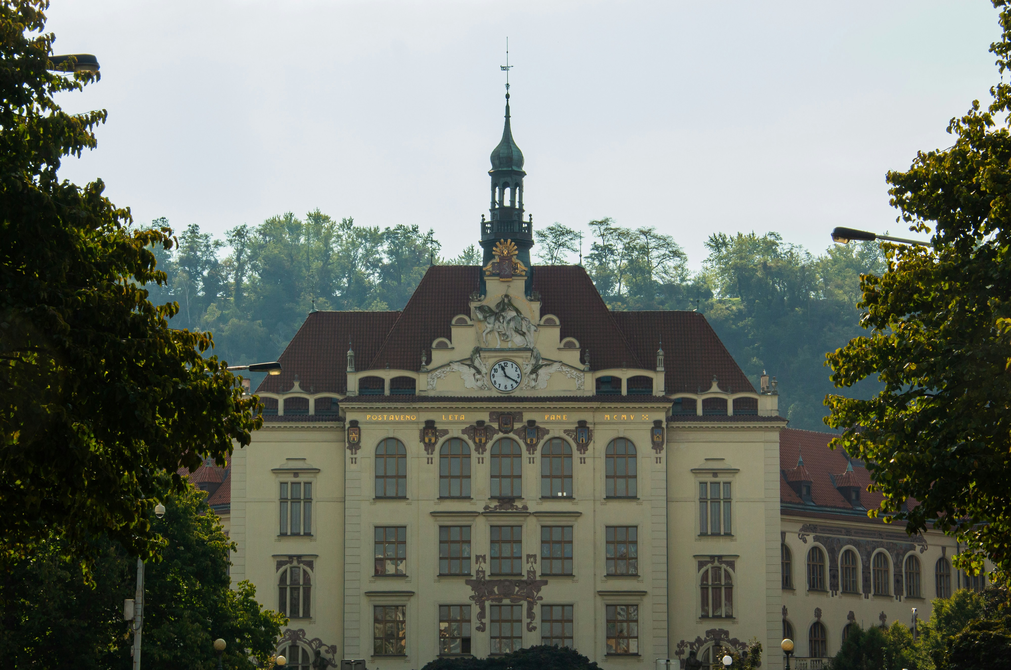 Ornate building with a clock tower framed by trees