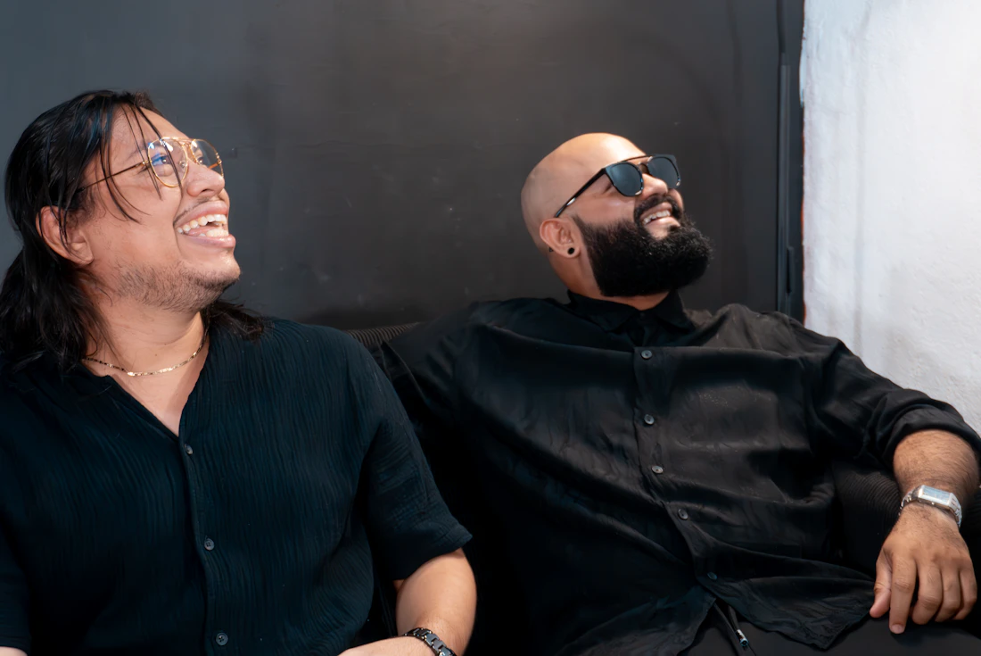 Two men laughing together on a couch