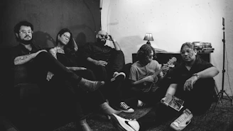 A group of five people sitting together in a room.