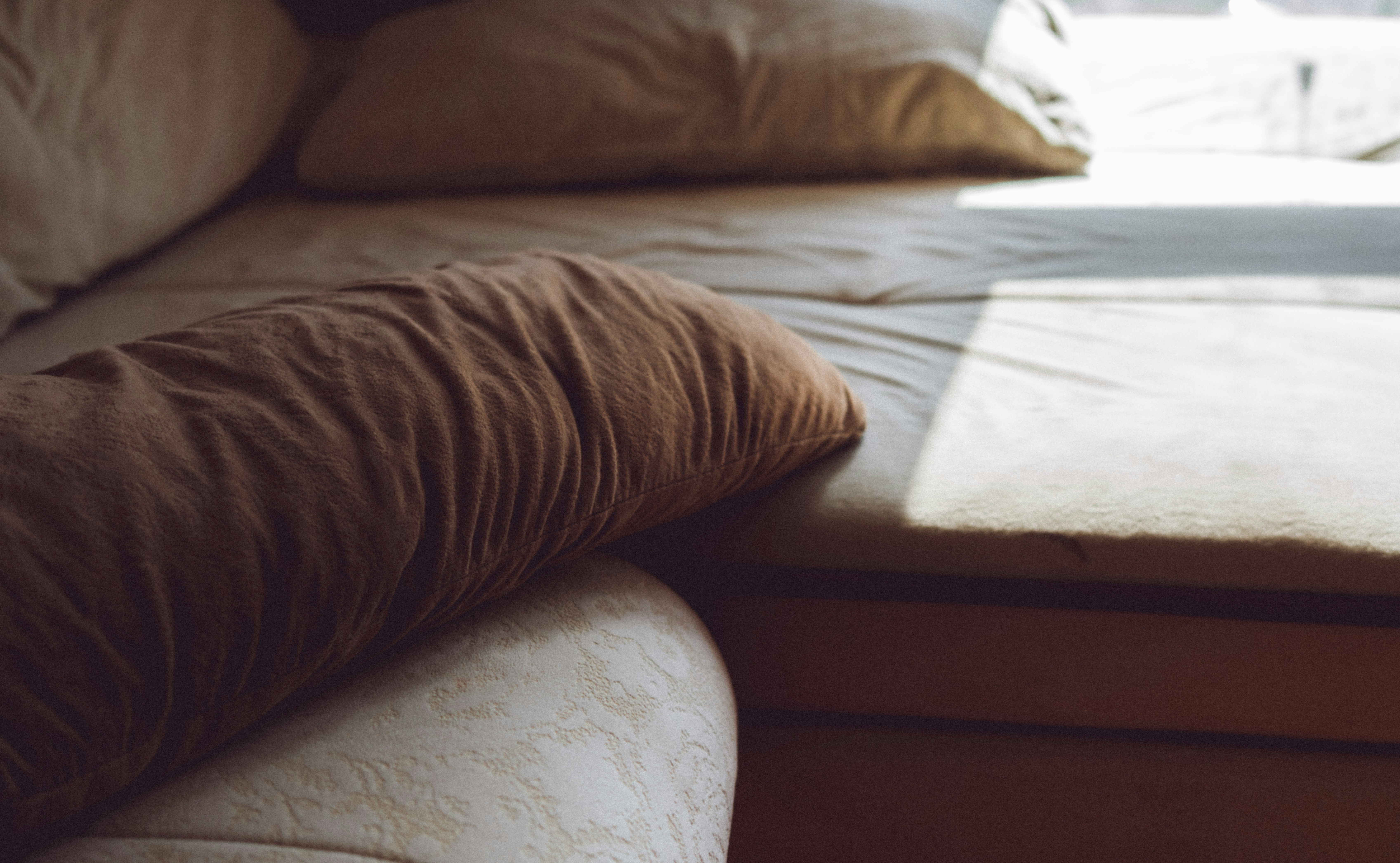 A bed with pillows near a window