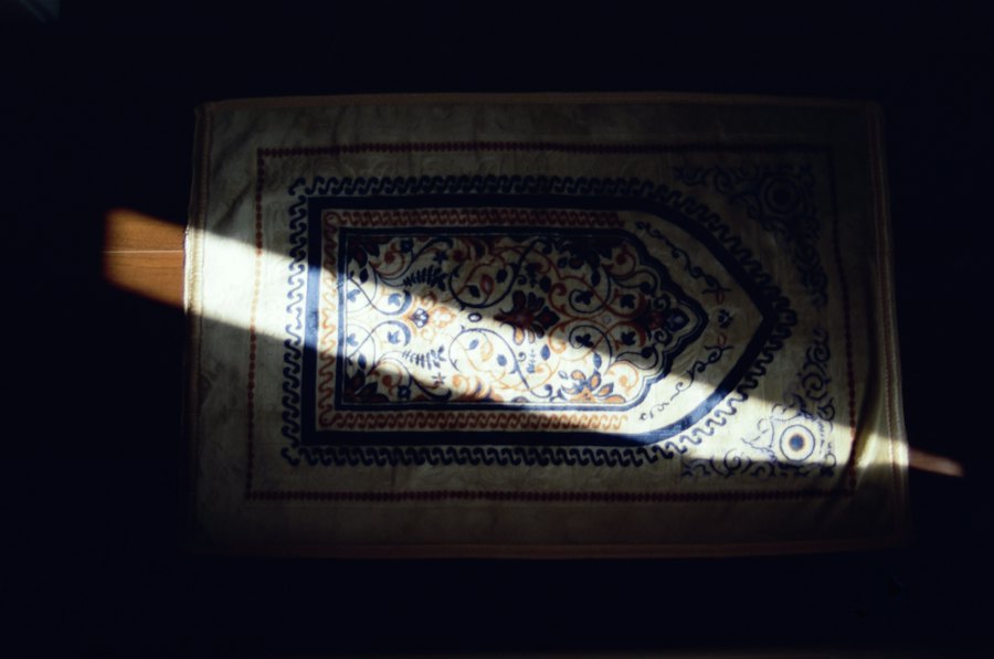 A prayer mat lit by a beam of light