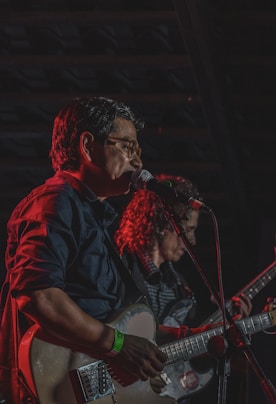 Musicians playing guitars on stage during a performance.