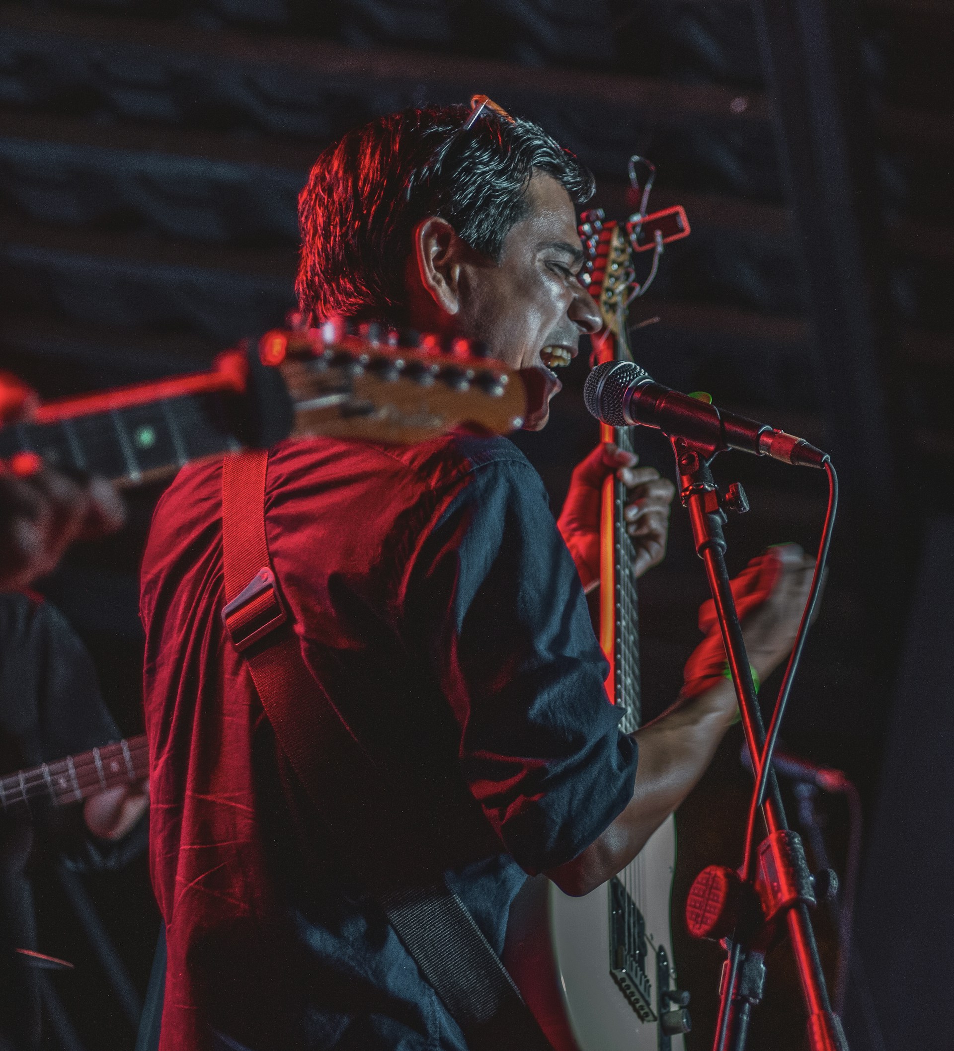 Man singing and playing guitar on stage