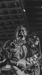 Man singing and playing guitar on stage