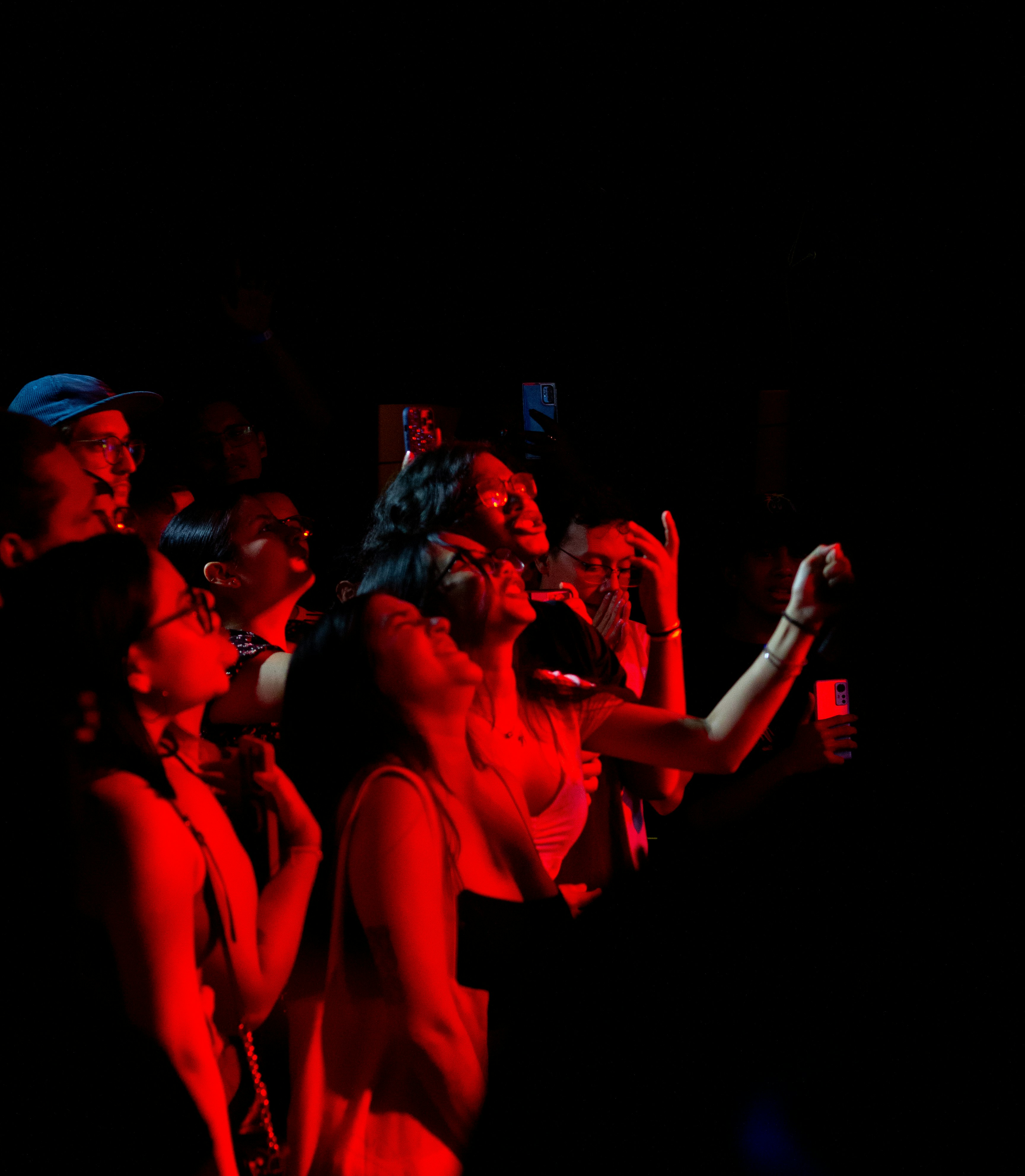 Crowd watching a performance under red lights