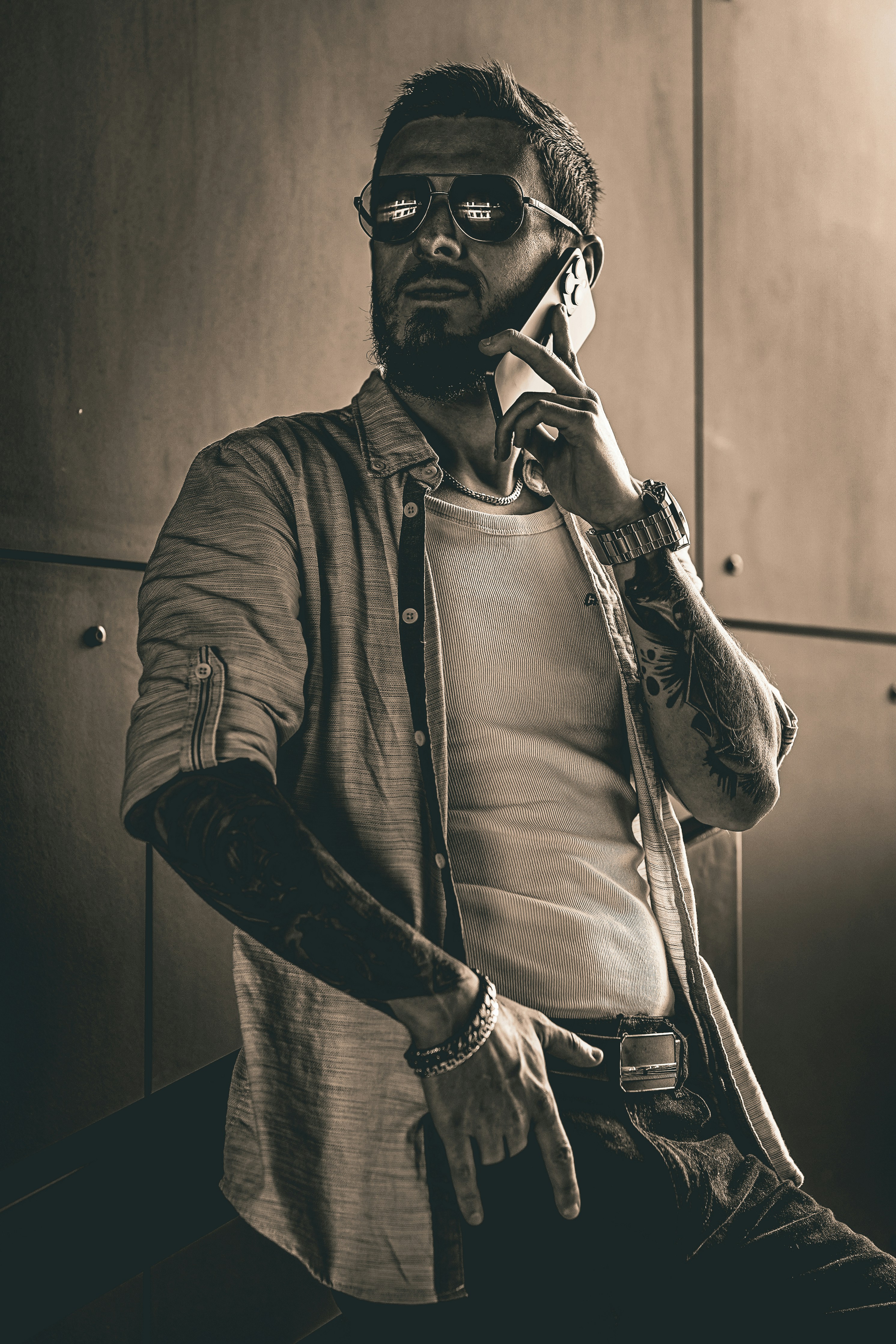 Man in sunglasses talking on a cell phone.