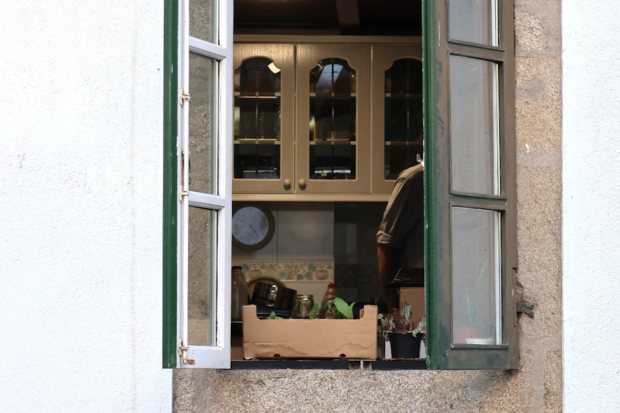Offenes Küchenfenster mit grünen Rahmen, auf dem Sims eine Holzkiste
