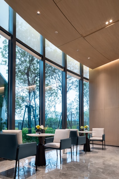 Modern seating area with large windows and trees outside.