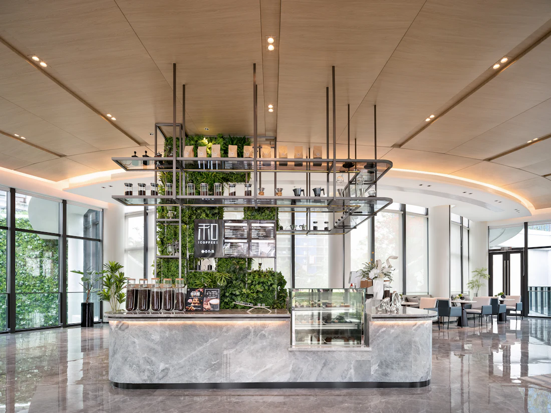 Interior of a modern cafe counter with seating and planting