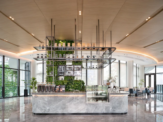Modern coffee bar with lush greenery and marble counter