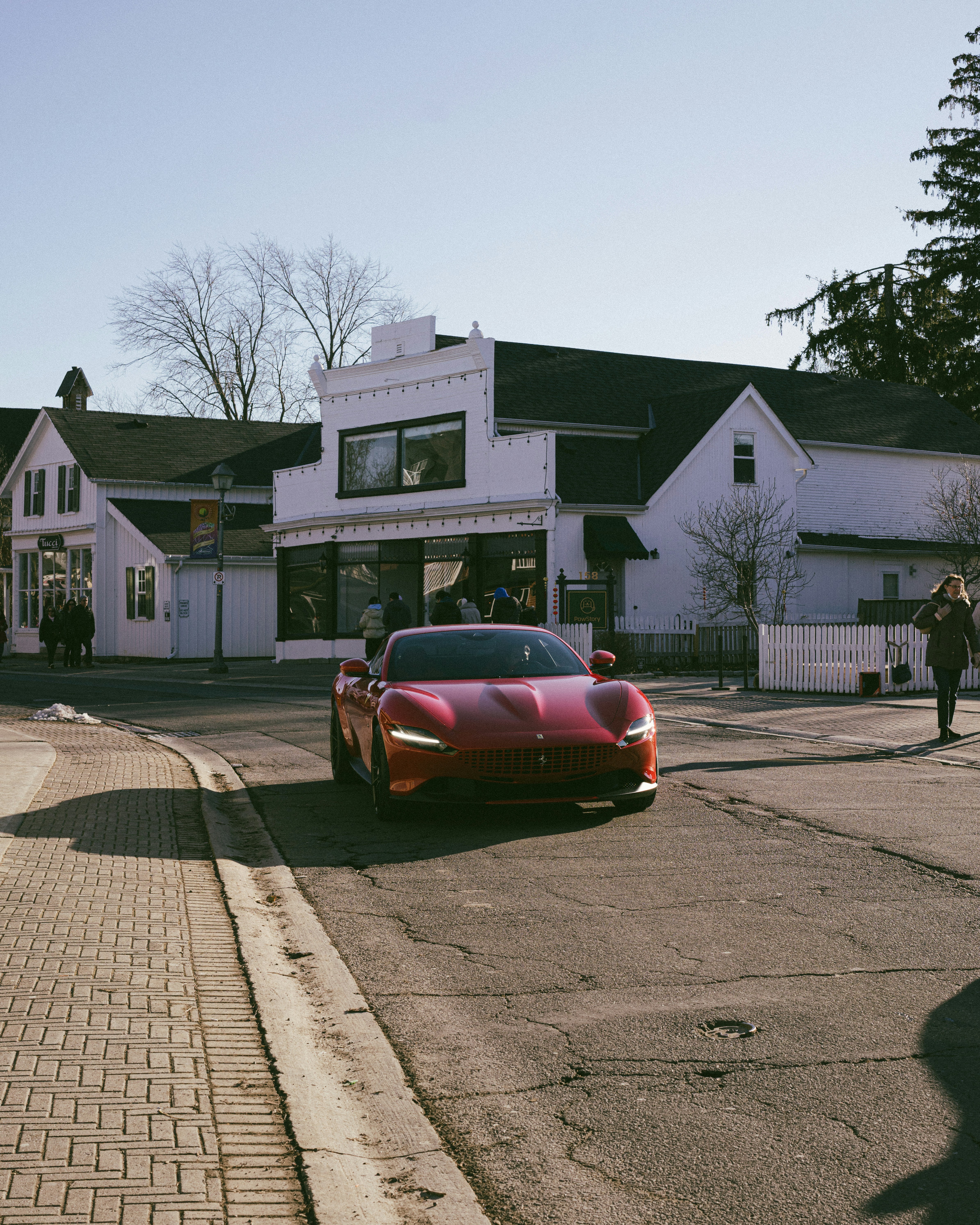 Red sports car driving down a street