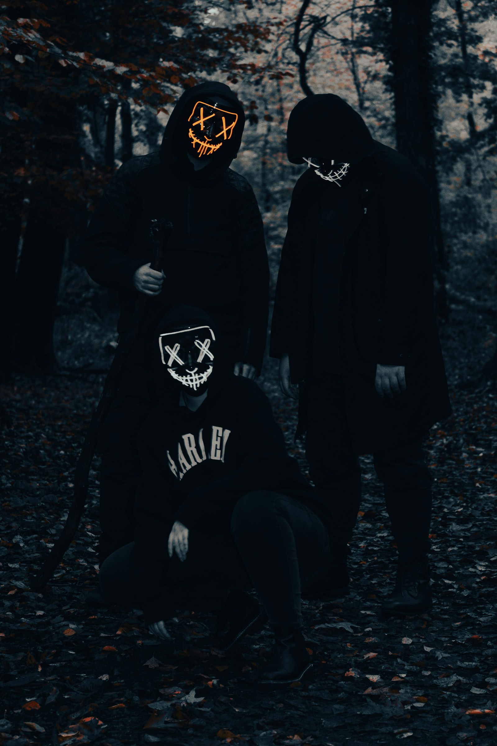 Three masked figures in the dark
