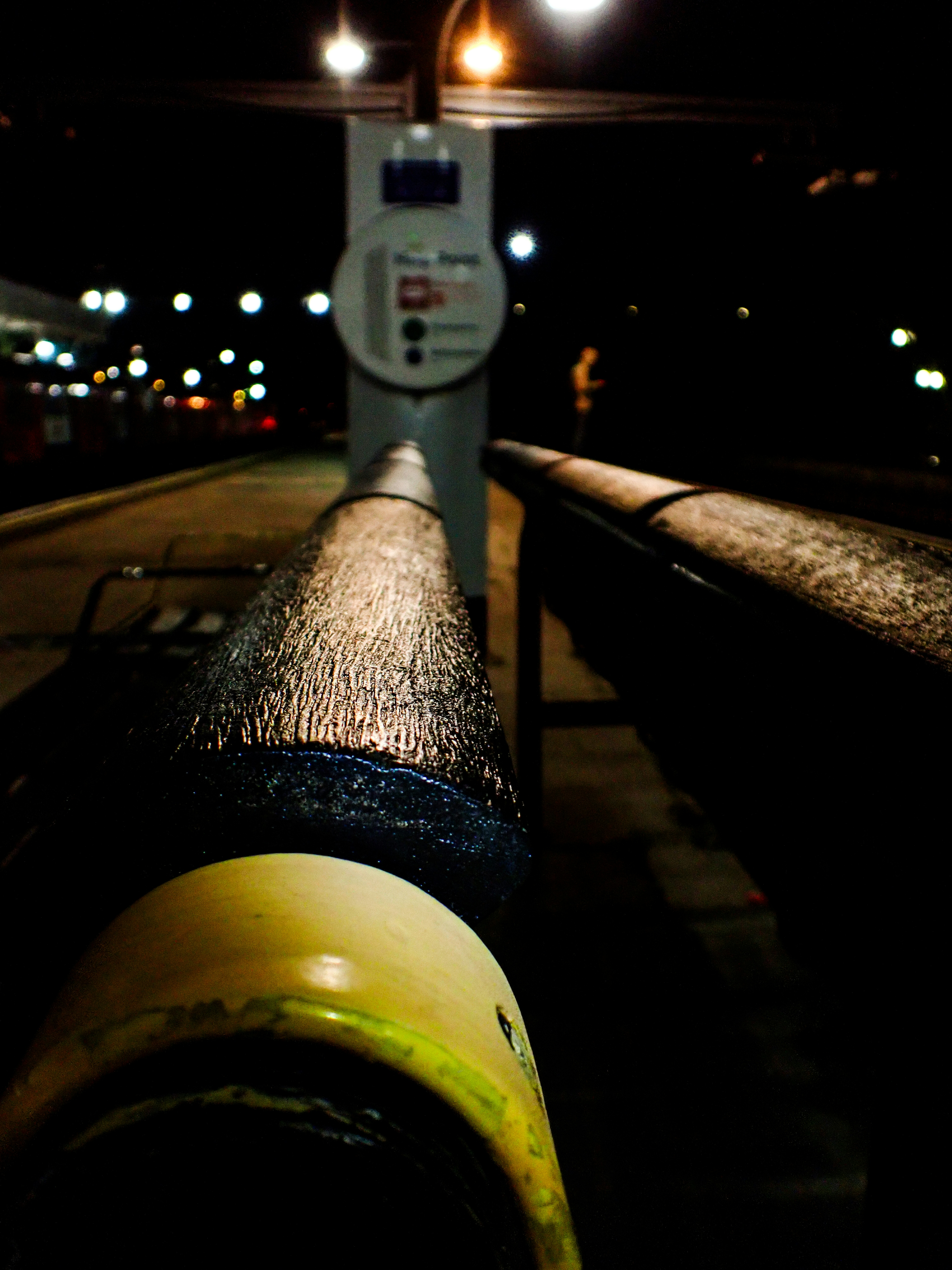 Empty train station platform at night with lights.