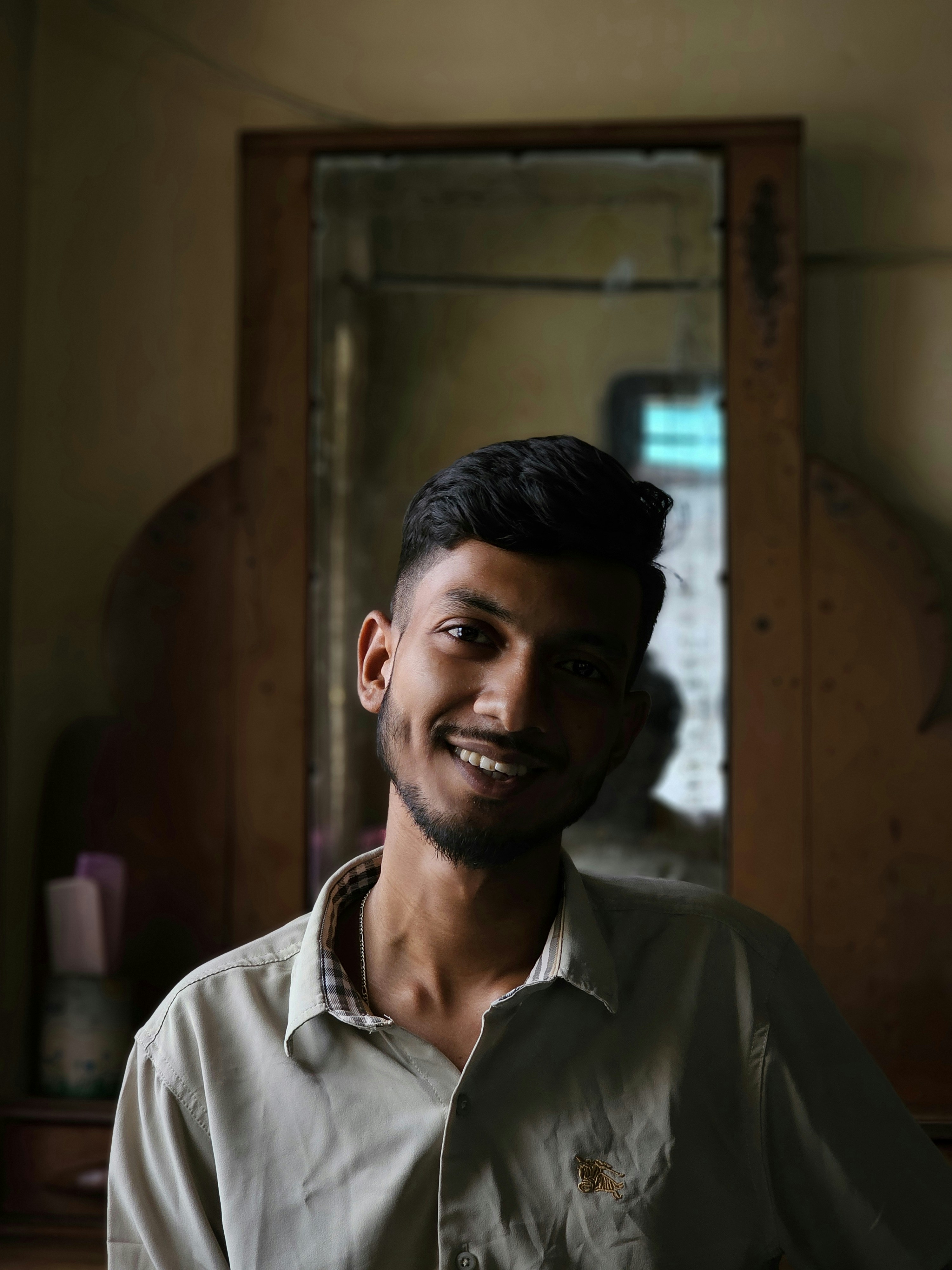 Young man with dimples smiling in a collared shirt