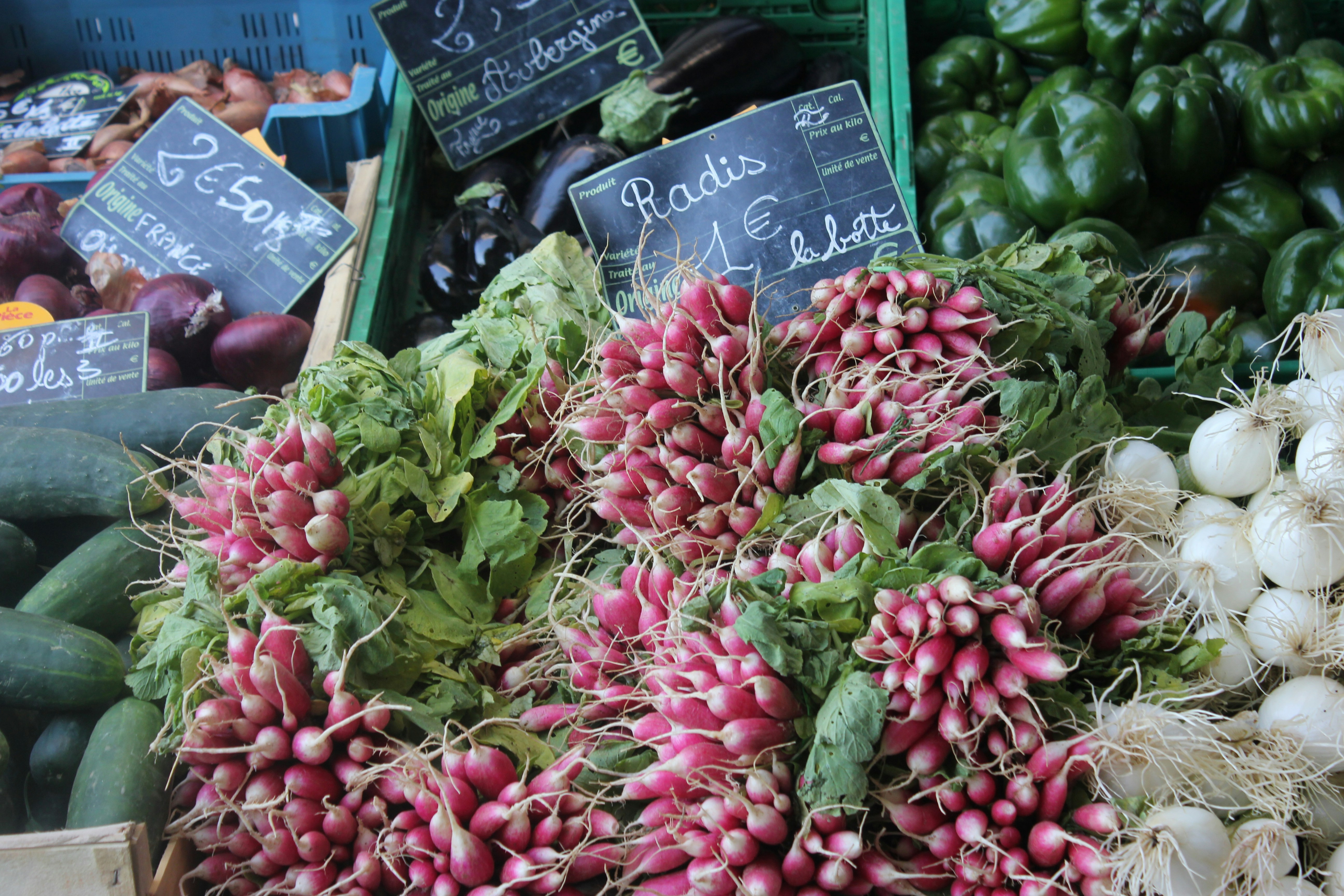 Fresh radishes and vegetables at a market stall.