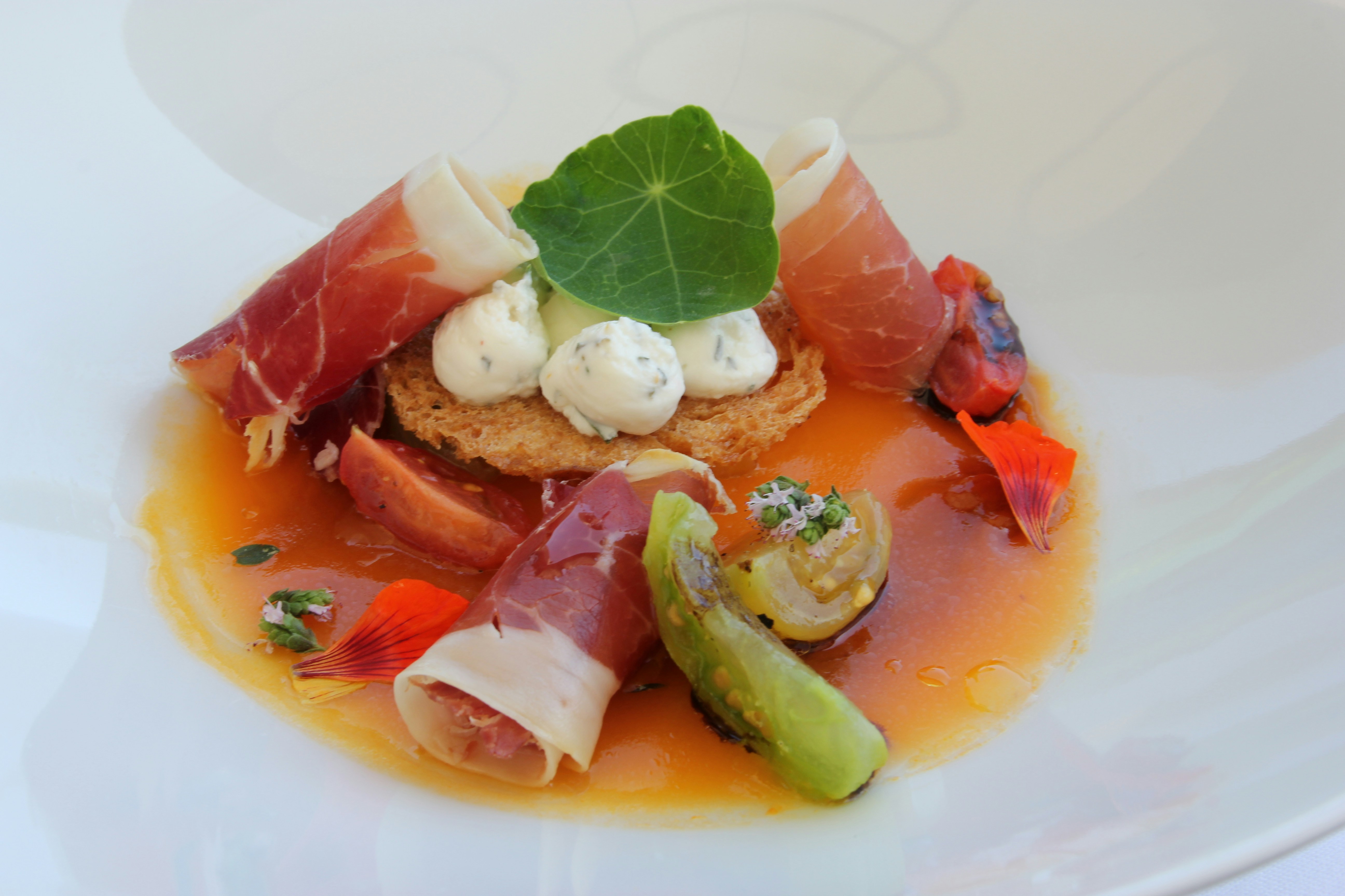 Gourmet appetizer with prosciutto, cheese, and vegetables