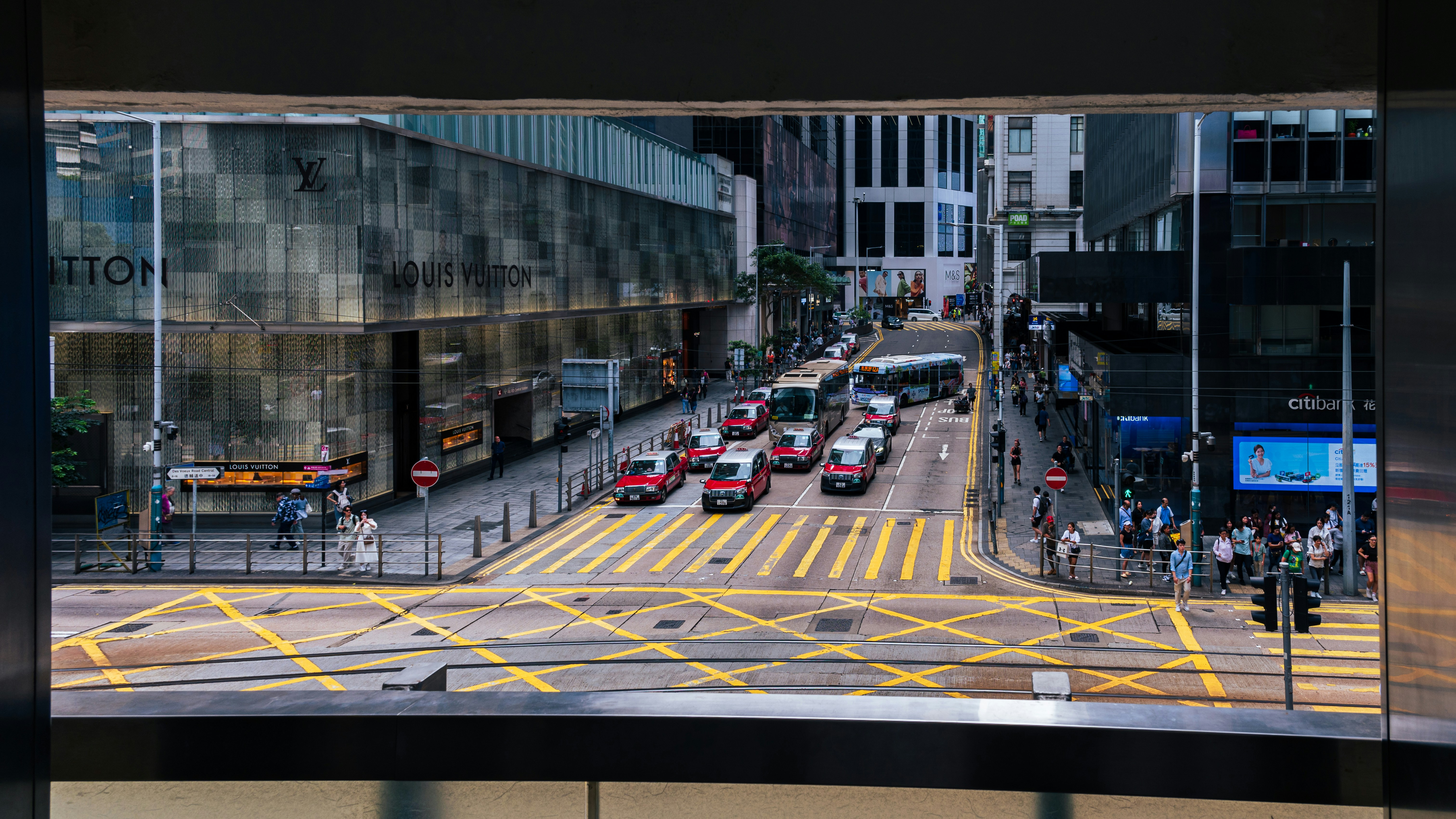 Busy city street with taxis and buses.