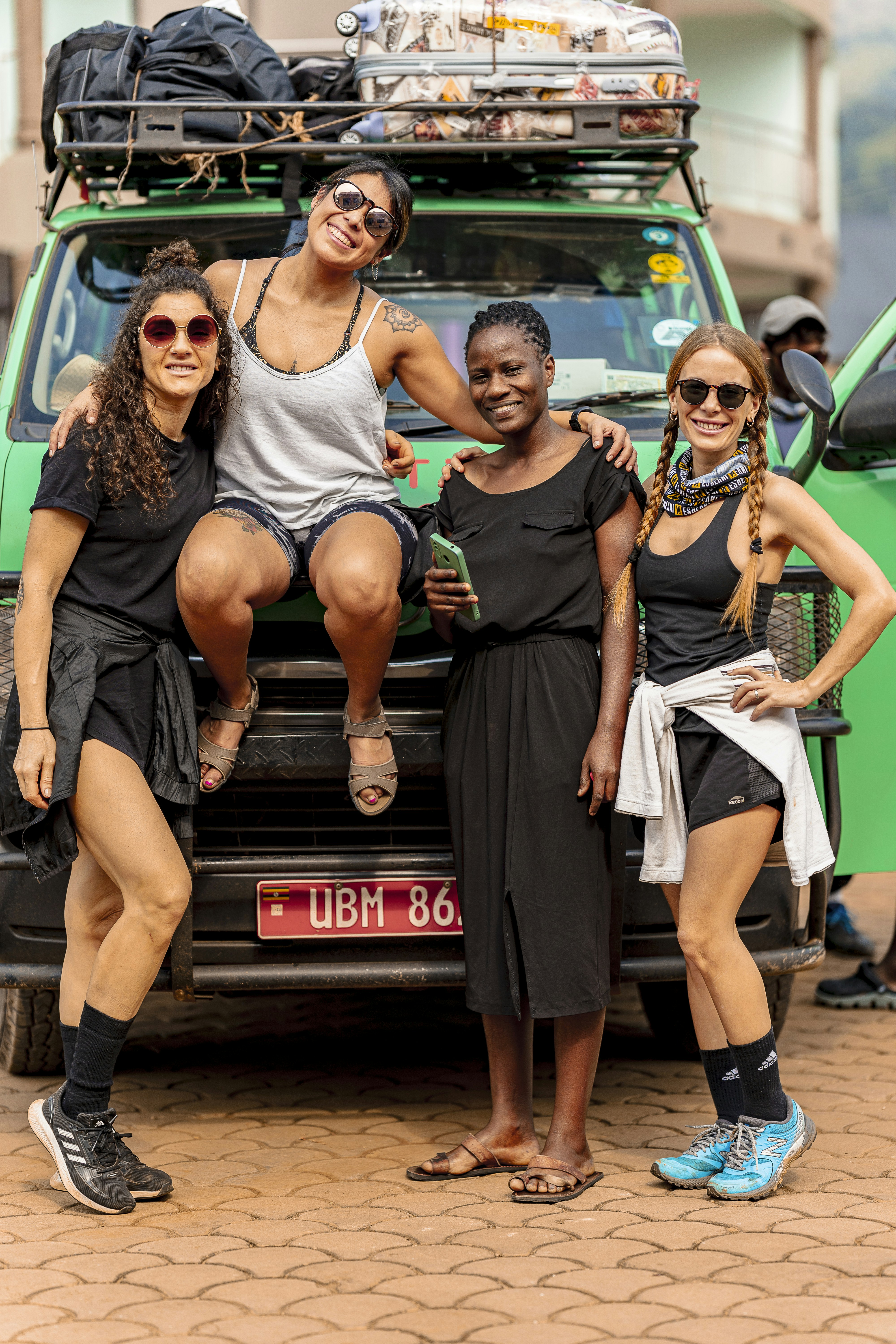 Quatre femmes posant devant une camionnette d’aventure verte.